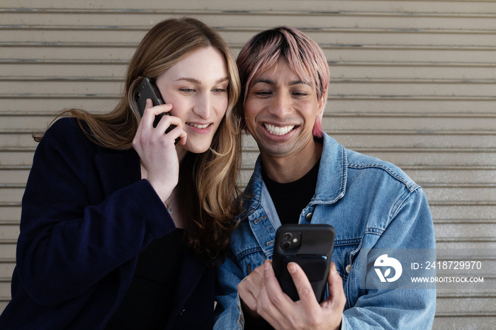 Lgbtqia friends laughing on their phone.