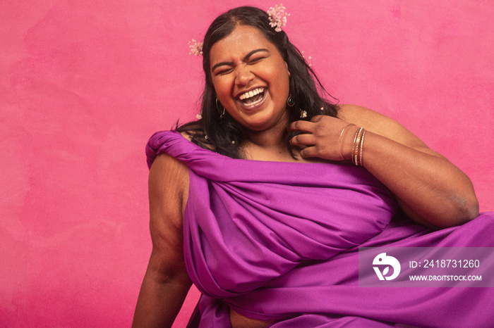 马来西亚裔印度人在粉色背景的工作室里大笑并摆姿势