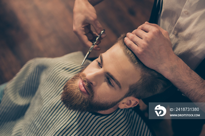 Close up cropped photo of a hairdresser`s work for an attractive guy at the barber shop. He is doing