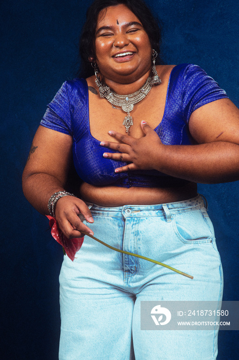 portrait of dark skinned Indian woman from Malaysia against a dark blue background