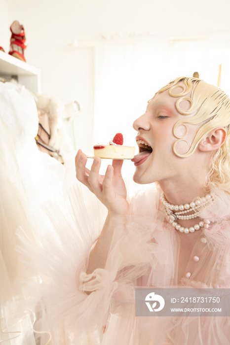 close up of non-binary hispanic person playfully eating a pretty dessert