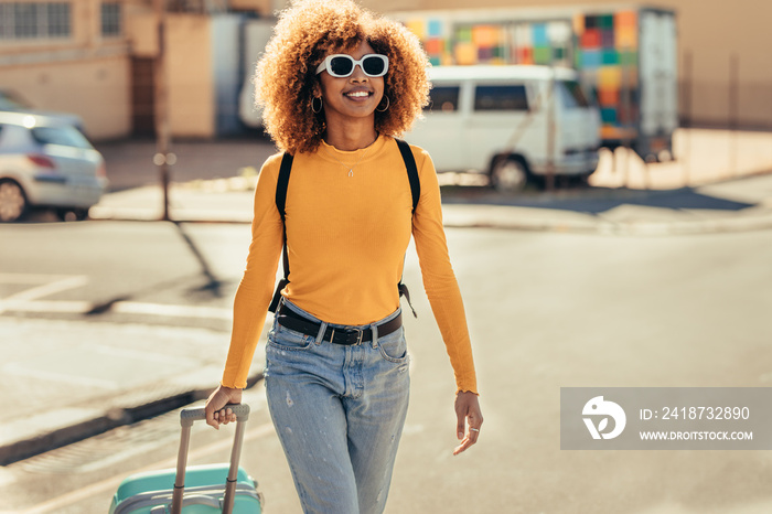 Cheerful woman traveller walking on street