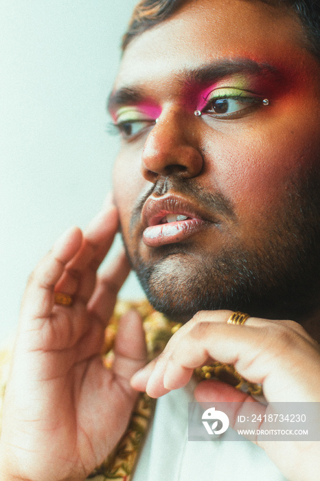 portrait of dark skinned Indian man against white wall