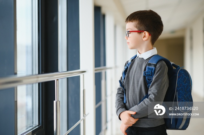 学校里带着书包和书的男孩。教育理念。回到学校。学生去了