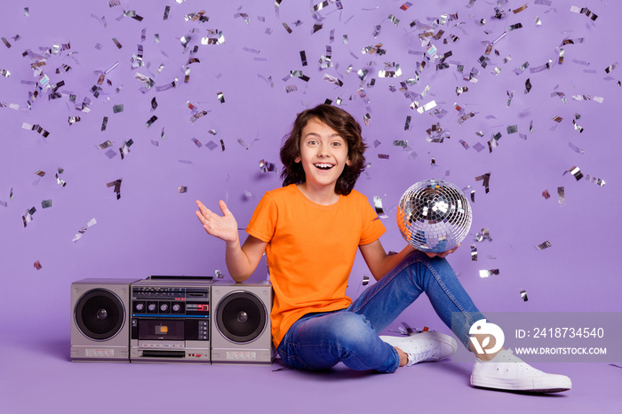 Portrait of attractive cheerful boy with tape player having fun decor falling isolated over violet p