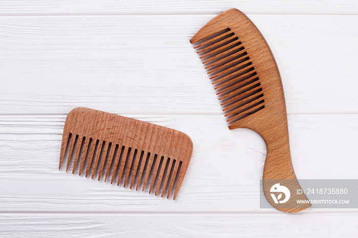 Wooden hair combs on white background. Natural brown hair combs on wooden surface.