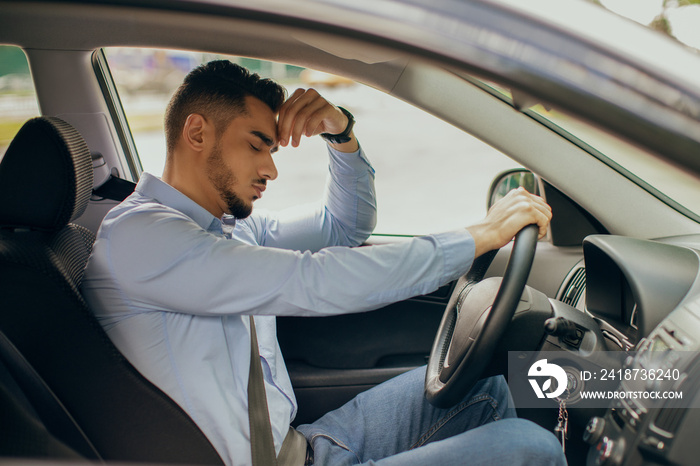 Upset arab businessman driver touching his head, stuck in traffic