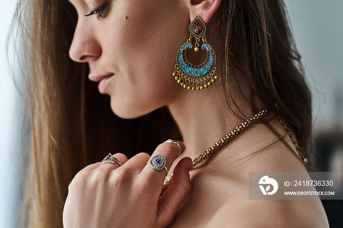 时尚性感的波西米亚风格的女人，戴着大耳环、金项链和带石头的银戒指。时尚