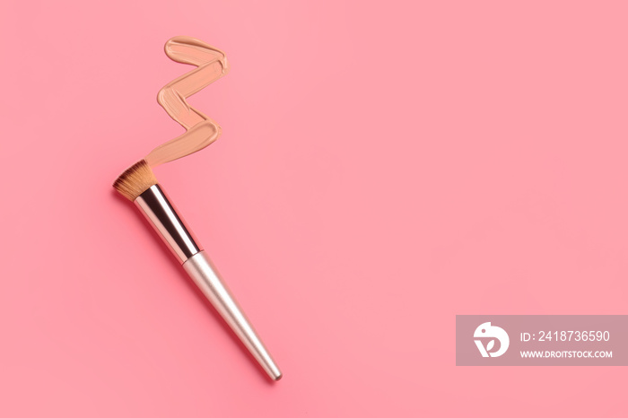 Sample of makeup foundation and brush on color background