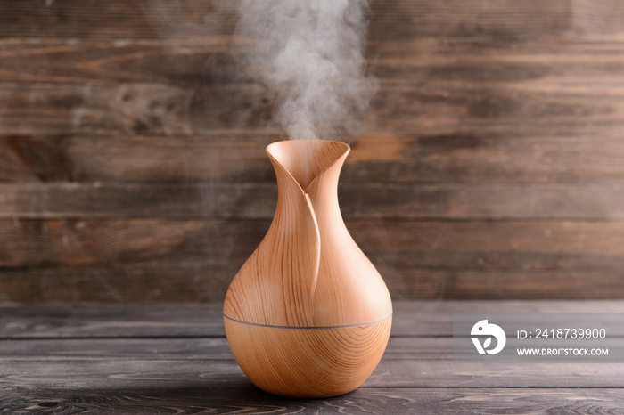 Aroma oil diffuser on wooden background