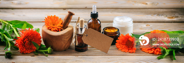 金盏花芳香疗法。精油和化妆品，空白标签，横幅。木桌背景