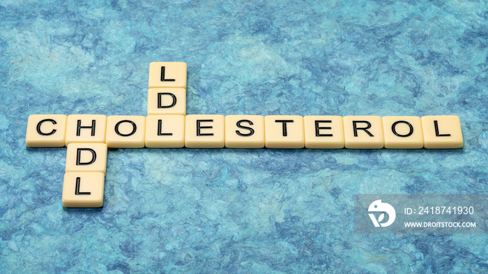 hdl and ldl  cholesterol crossword in ivory letter tiles against textured handmade bark paper, healt