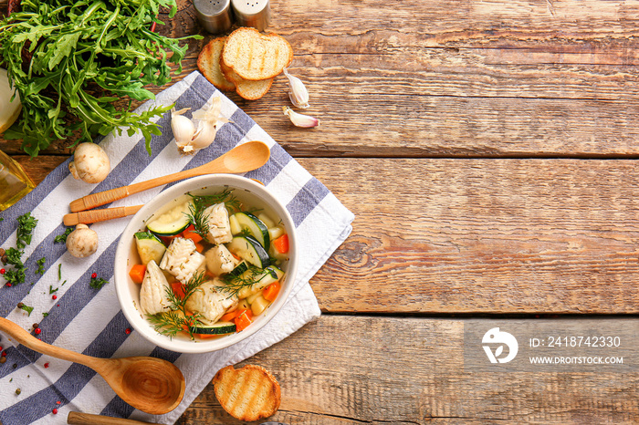 Bowl of tasty soup on wooden table