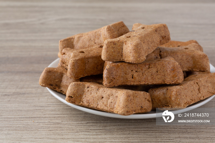 Side close view of peanut butter dog biscuits on a white plate