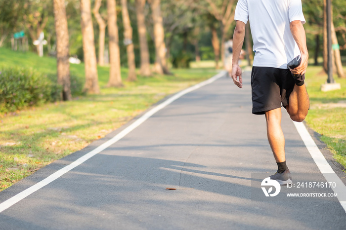 Young athlete man streching in the park outdoor. male runner warm up ready for jogging on the road o