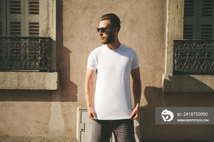 Hipster handsome male model with beard wearing white blank t-shirt with space for your logo or desig