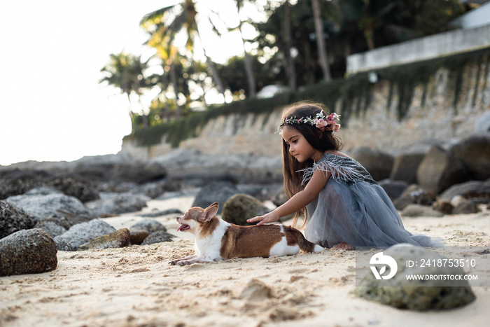 Friendly portrait of a preschool girl and her pet on coast they having a good time together on vacat