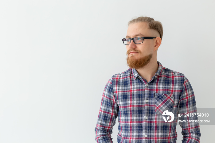 Portrait of thoughtful light blonde man with red beard over white background with copy space