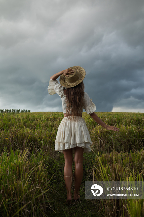 Carefree woman wearing straw hat in the rice field