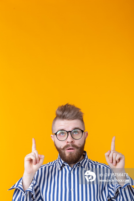 Solution is here. Handsome funny young man pointing copy space and looking up while standing against