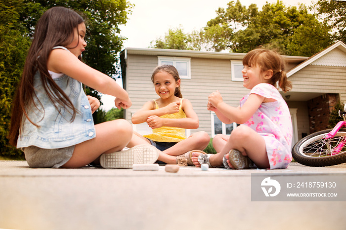 Girls (2-3, 8-9) playing in street