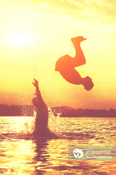 Glückliche junge Menschen laufen und springen am See beim Sonnenuntergang