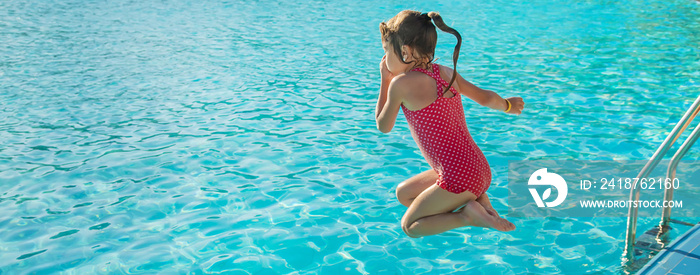 the child swims and dives in the pool. Selective focus.