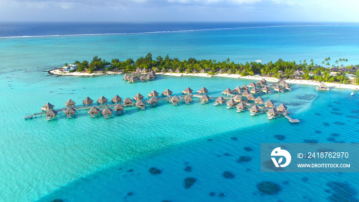 DRONE: Stunning view of the wooden overwater villas above the turquoise sea.