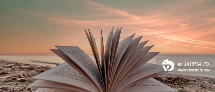 Zénitude sur la plage. Livre ouvert sur une plage avec coucher de soleil.