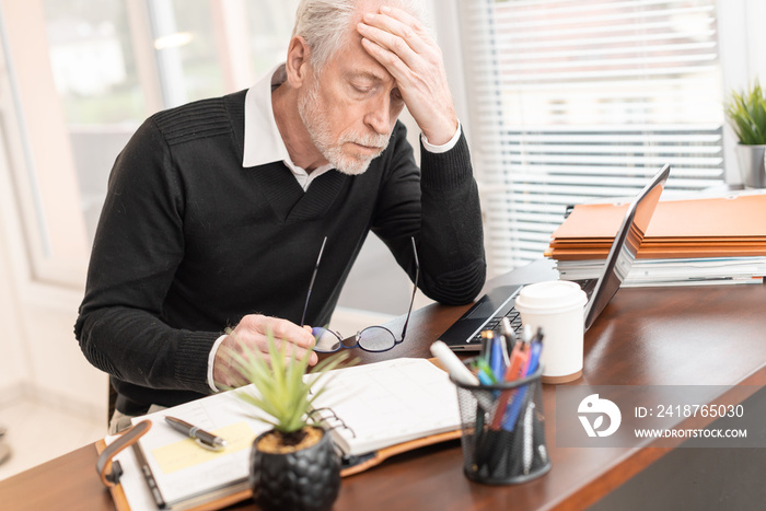 Portrait of overworked senior businessman