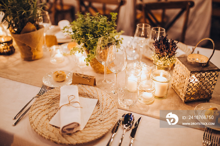 婚宴区的节日餐桌上有盘子、玻璃杯、蜡烛、餐具，桌子是装饰品