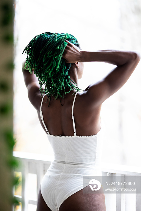 Black woman on patio playing with hair and enjoying nature