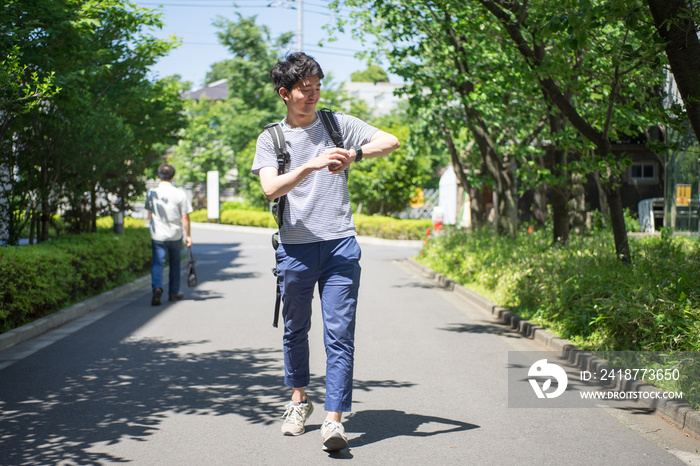 並木道を歩く男性