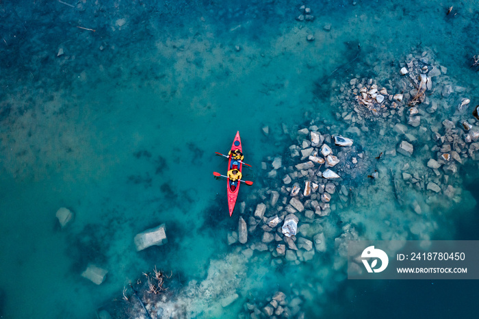 two athletic man floats on a red boat in river