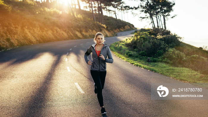 Woman athlete running on road in the morning