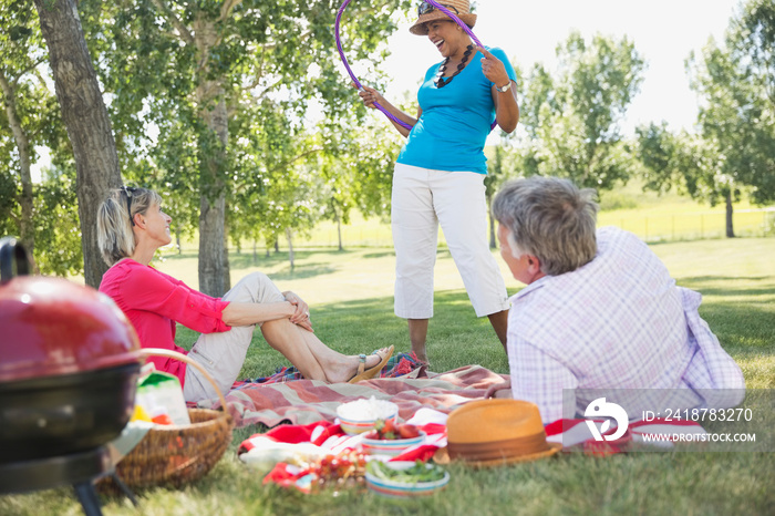 Middle-aged friends enjoying picnic at the park