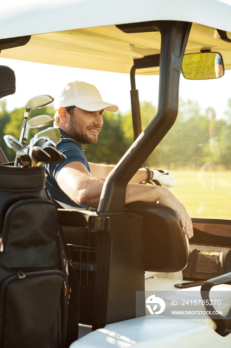 坐在高尔夫球车里微笑的男高尔夫球手