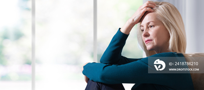 饱受压力或头痛折磨的女人痛苦地做鬼脸。悲伤沮丧的女人坐在家里