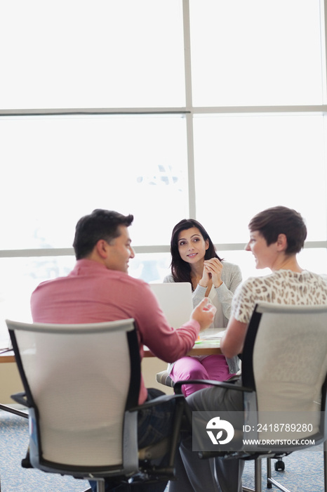 Businessman talking with female colleagues at office