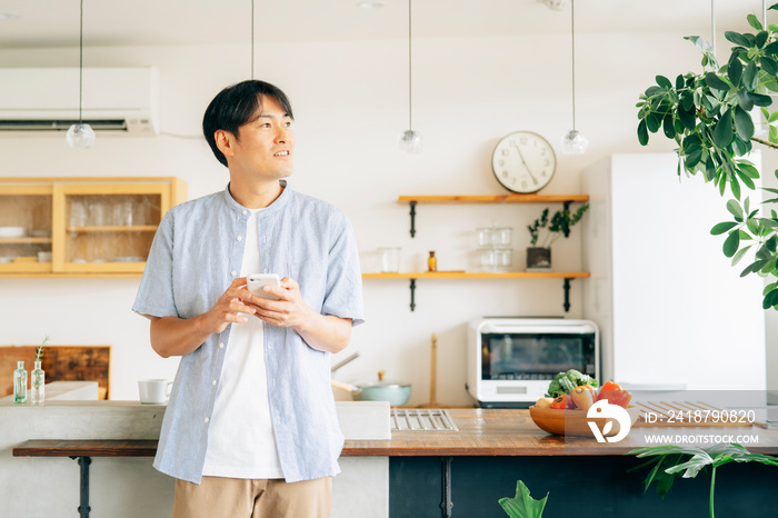 家でスマホを使う男性（アプリ）