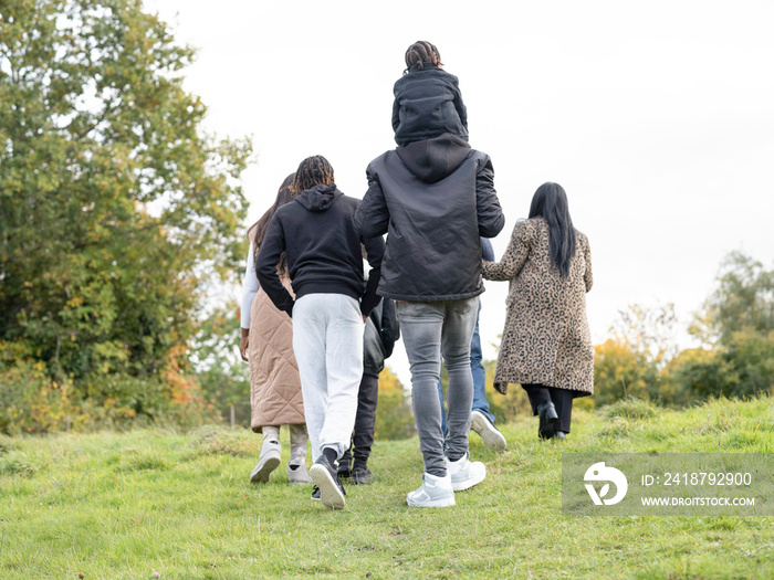 Rear view of family walking in meadow