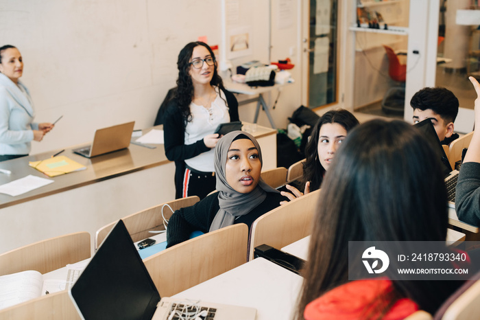 Multi-ethnic classmates sharing ideas during lecture in university