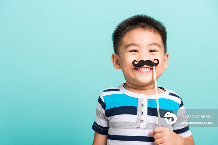 Funny happy hipster kid holding black mustache props for the photo booth close face, studio shot iso