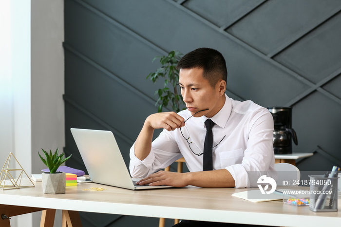 Asian businessman working on laptop in office