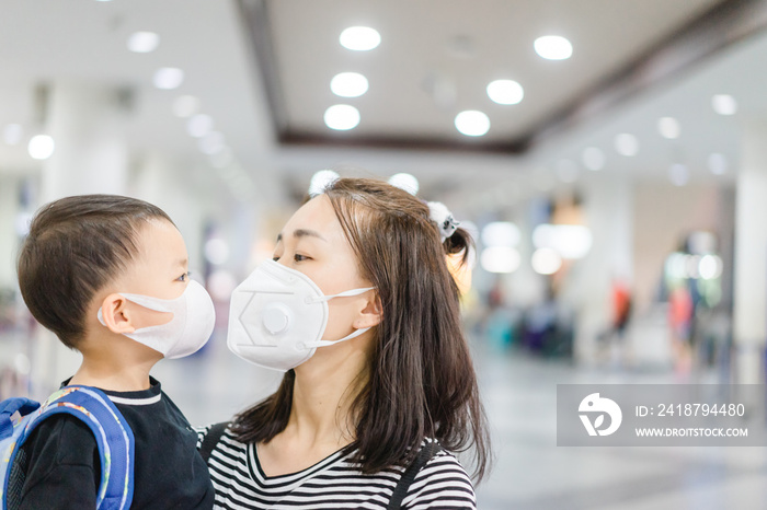 Coronavirus and Air pollution pm2.5 concept.Little chinese boy and chinese mother wearing mask for p