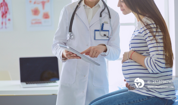 Beautiful smiling pregnant woman with the doctor at hospital