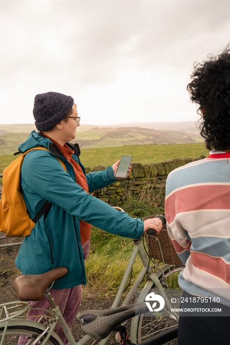 Female friends cycling on rural road