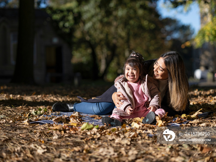 Mother and daughter with Down syndrome playing in park