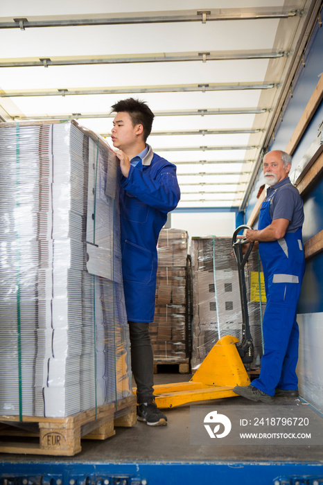 Factory worker operating pallet jack