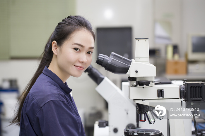 女科学家在实验室显微镜下观察